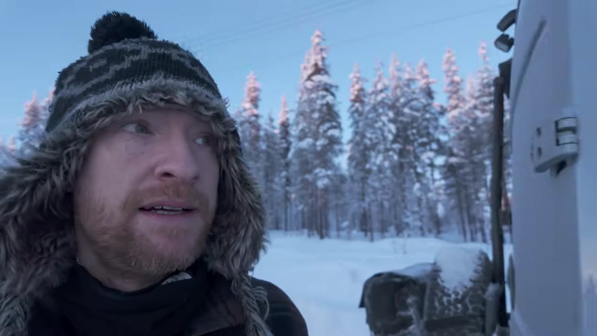Heaton walking among frost-covered trees in soft directional light