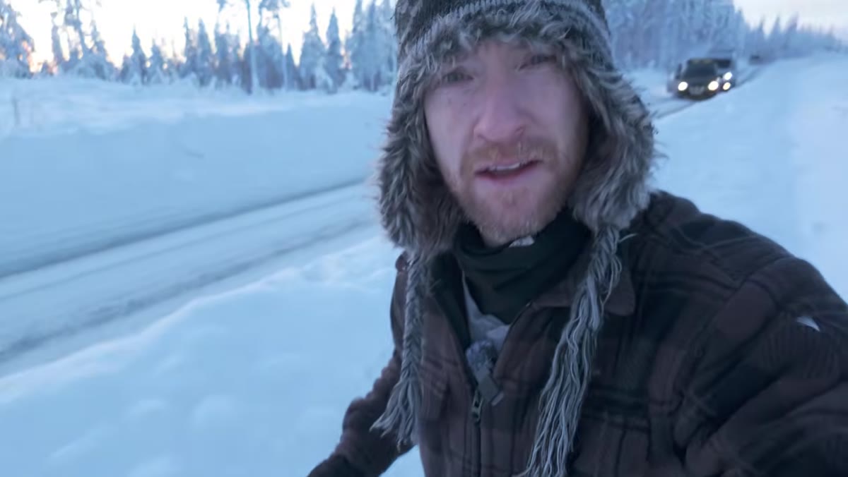 Heaton wading through thigh-deep snow toward a tree
