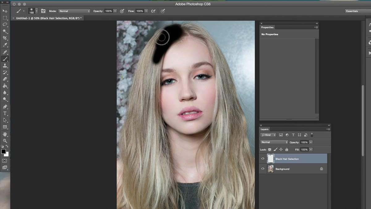 Black brush being painted over the subject&rsquo;s hair on a new layer